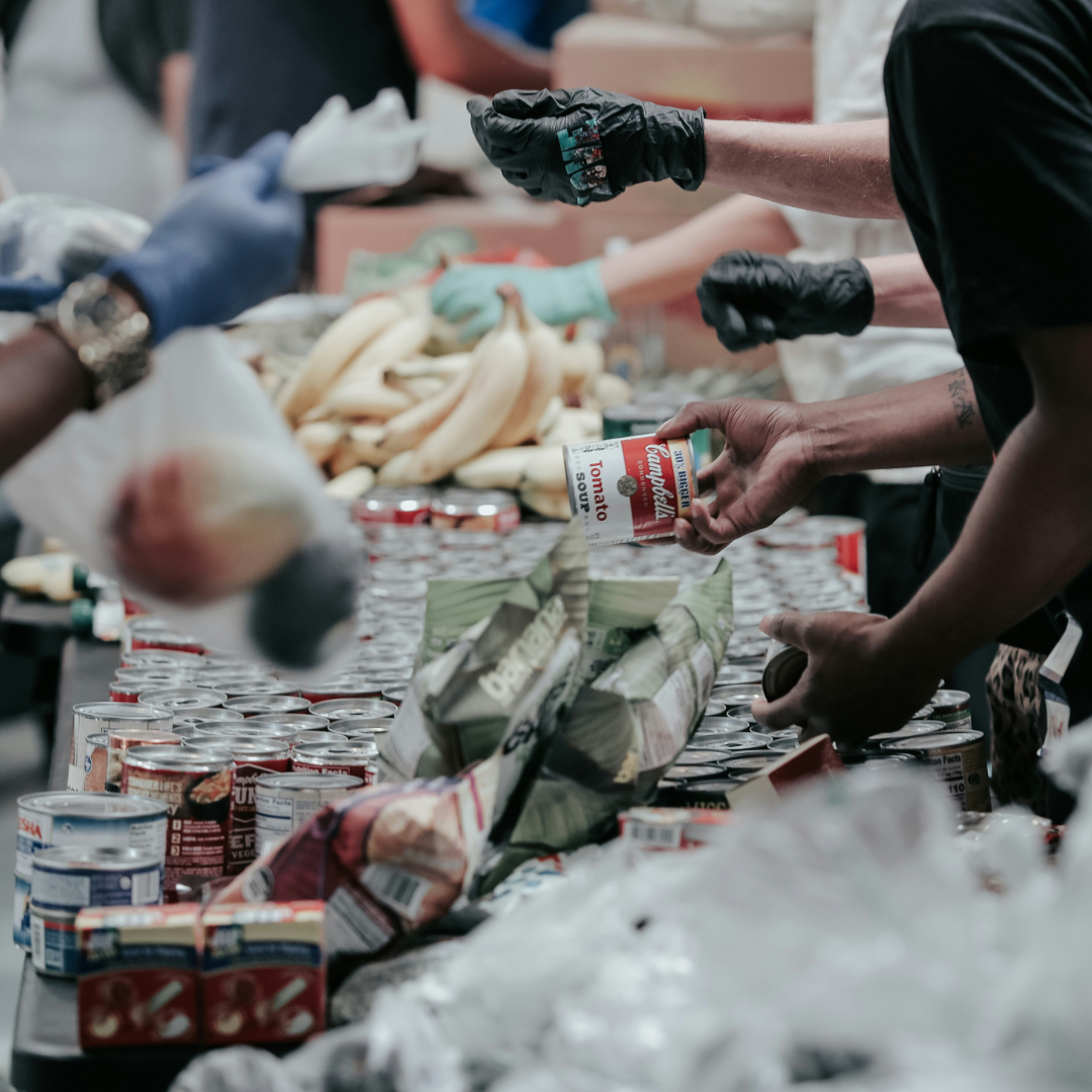 food pantry People gathered at a food pantry. Canned food items and bananas are pictures