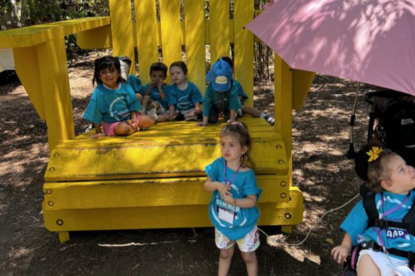 Group of children sitting on a yellow bench