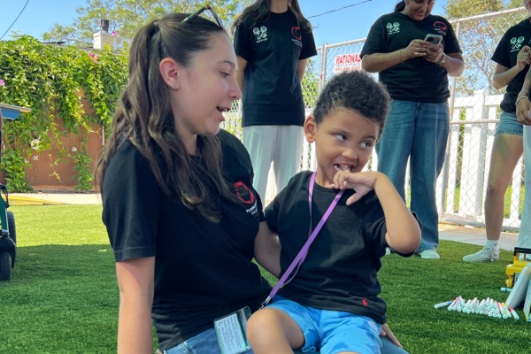 A child and a volunteer sitting together